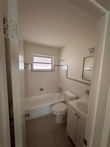 an empty room with wooden floor and mirror