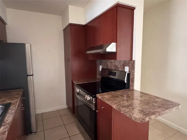 a kitchen with granite countertop a refrigerator and a stove