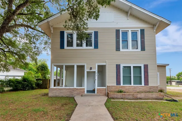 a front view of a house with garden and patio