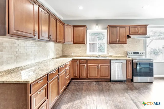 a kitchen with stainless steel appliances granite countertop a sink and cabinets