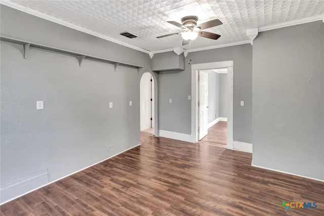 a view of an empty room with window and wooden floor