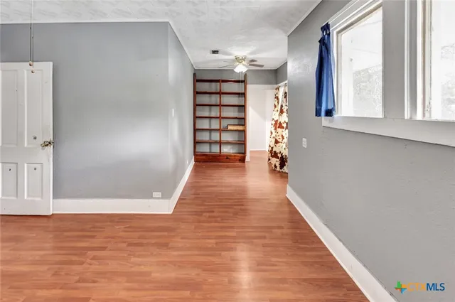 a view of a livingroom with wooden floor and a ceiling fan