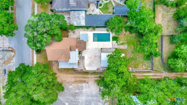 an aerial view of a house with a yard and large trees