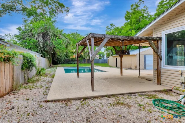 a view of backyard with green space and seating