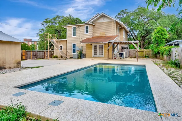 a front view of a house with a garden and trees