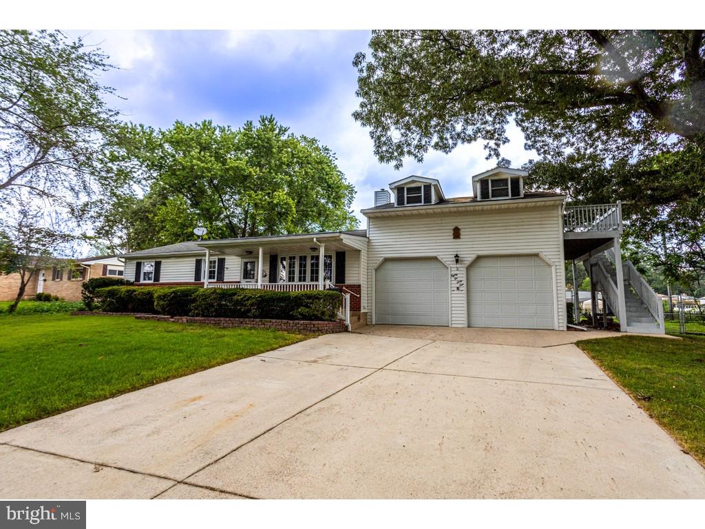 8261 Spring Knoll Drive Pasadena, MD 21122 - Photo 1 of 49 a front view of a house with a garden and trees