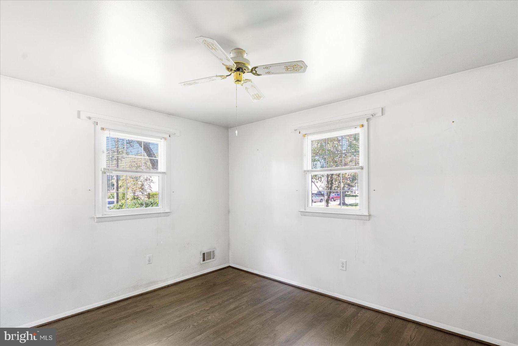 8261 Spring Knoll Drive Pasadena, MD 21122 - Photo 18 of 49 a view of an empty room with wooden floor and a window