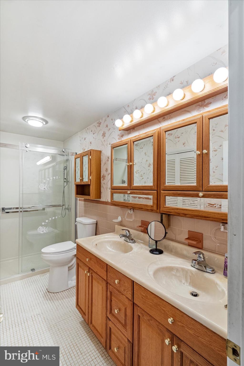 8261 Spring Knoll Drive Pasadena, MD 21122 - Photo 27 of 49 a bathroom with a double vanity sink and a mirror