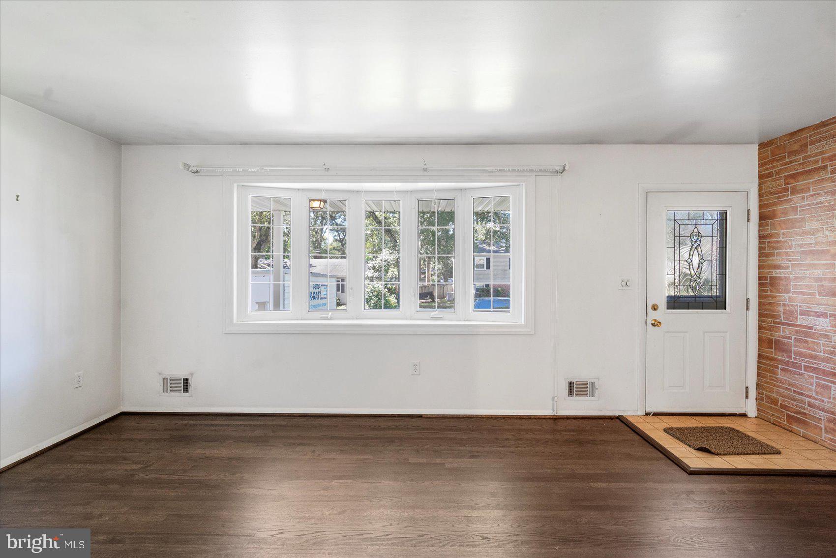 8261 Spring Knoll Drive Pasadena, MD 21122 - Photo 6 of 49 an empty room with wooden floor and windows