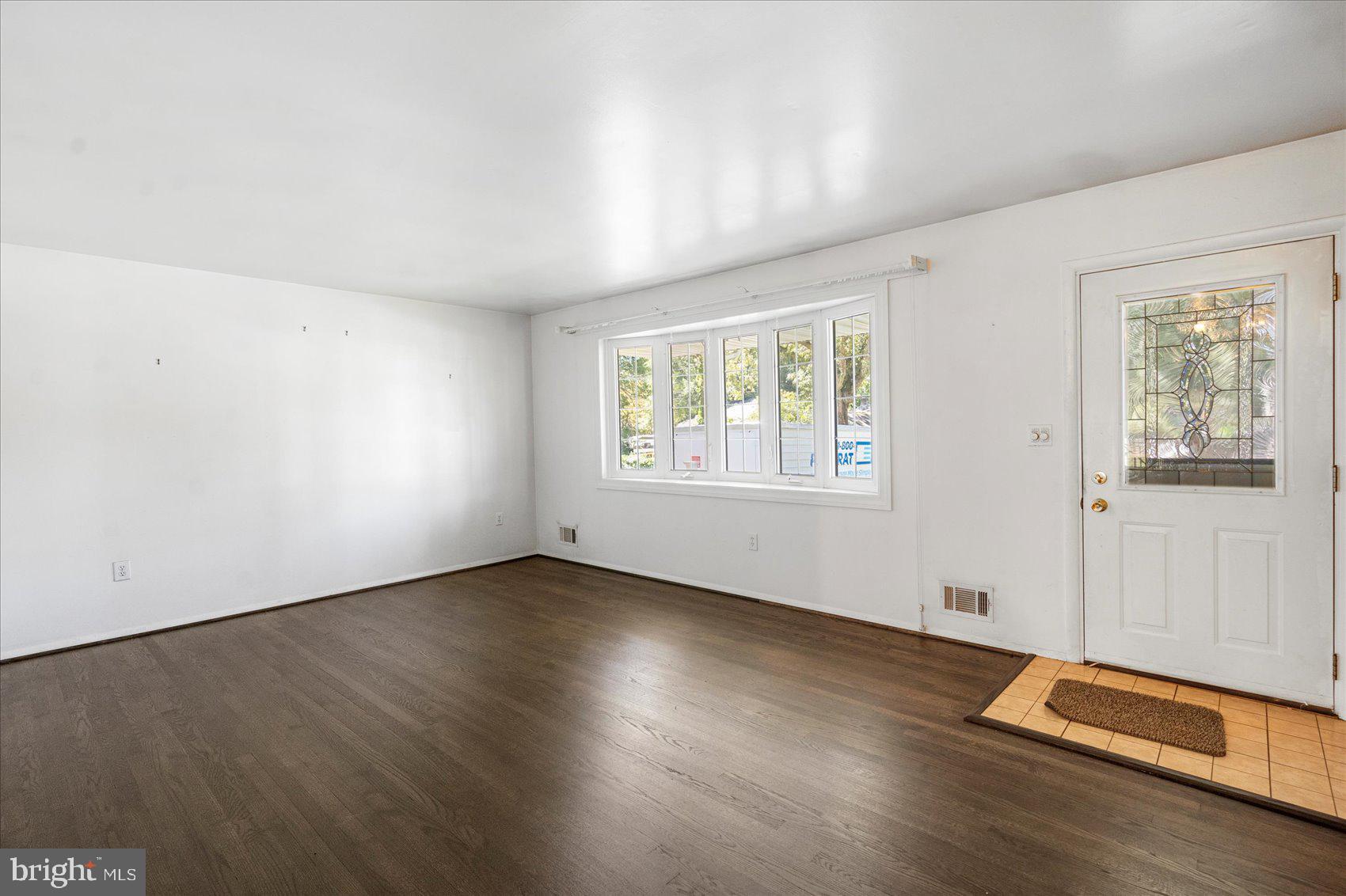 8261 Spring Knoll Drive Pasadena, MD 21122 - Photo 7 of 49 an empty room with wooden floor and windows