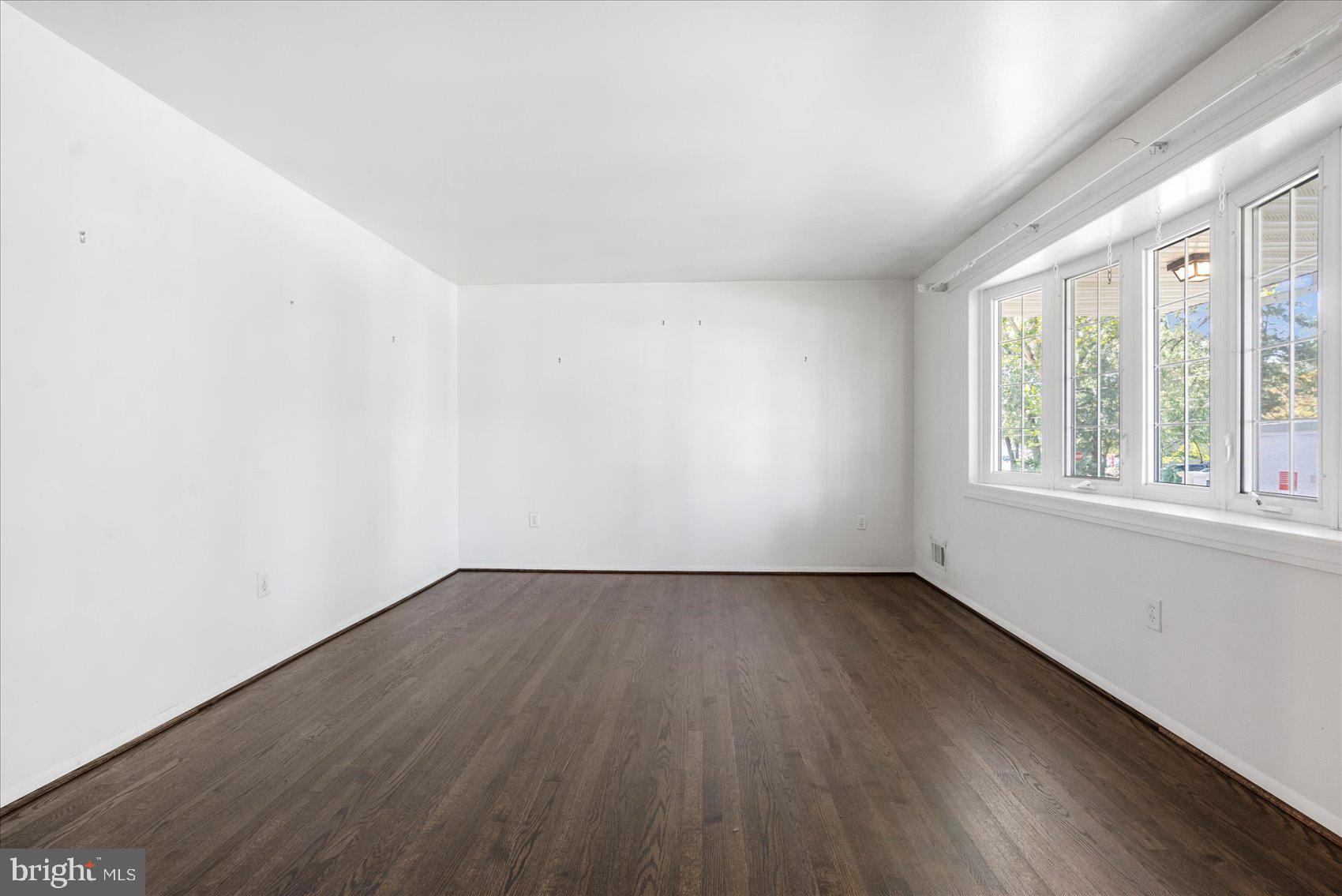 8261 Spring Knoll Drive Pasadena, MD 21122 - Photo 8 of 49 an empty room with wooden floor and windows