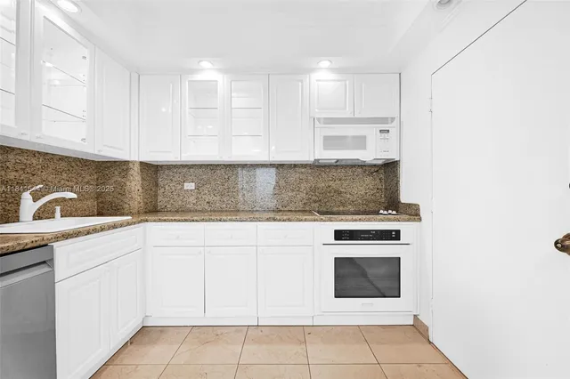 a kitchen with cabinets appliances and a sink