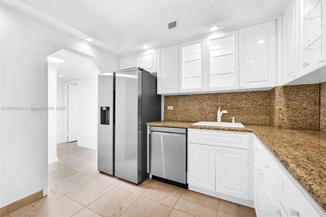 a kitchen with a refrigerator sink and cabinets