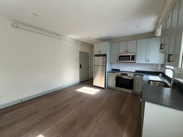 a kitchen with wooden floors and stainless steel appliances
