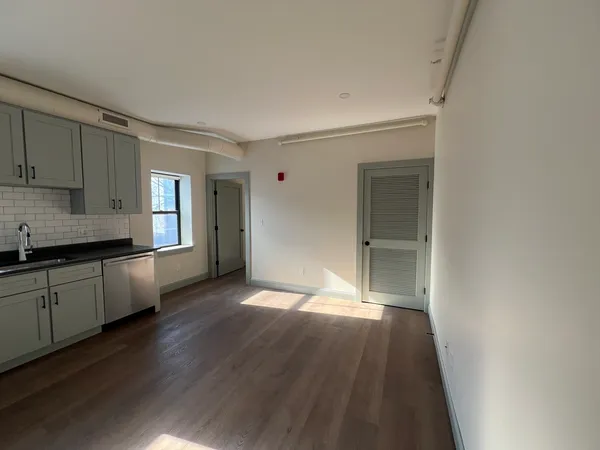 a view of a kitchen cabinets a sink and wooden floor