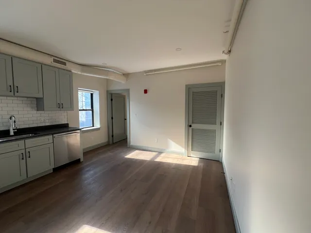 a view of a kitchen cabinets a sink and wooden floor