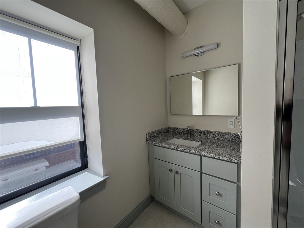160 Seabury Street, Unit 11 Fall River, MA 02720 - Photo 7 of 10 a bathroom with a granite countertop sink and mirror