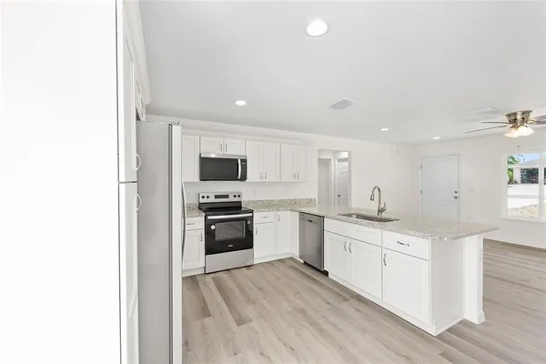 a kitchen with stainless steel appliances a sink stove and refrigerator