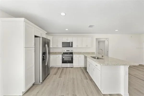 a kitchen with stainless steel appliances a refrigerator sink and stove