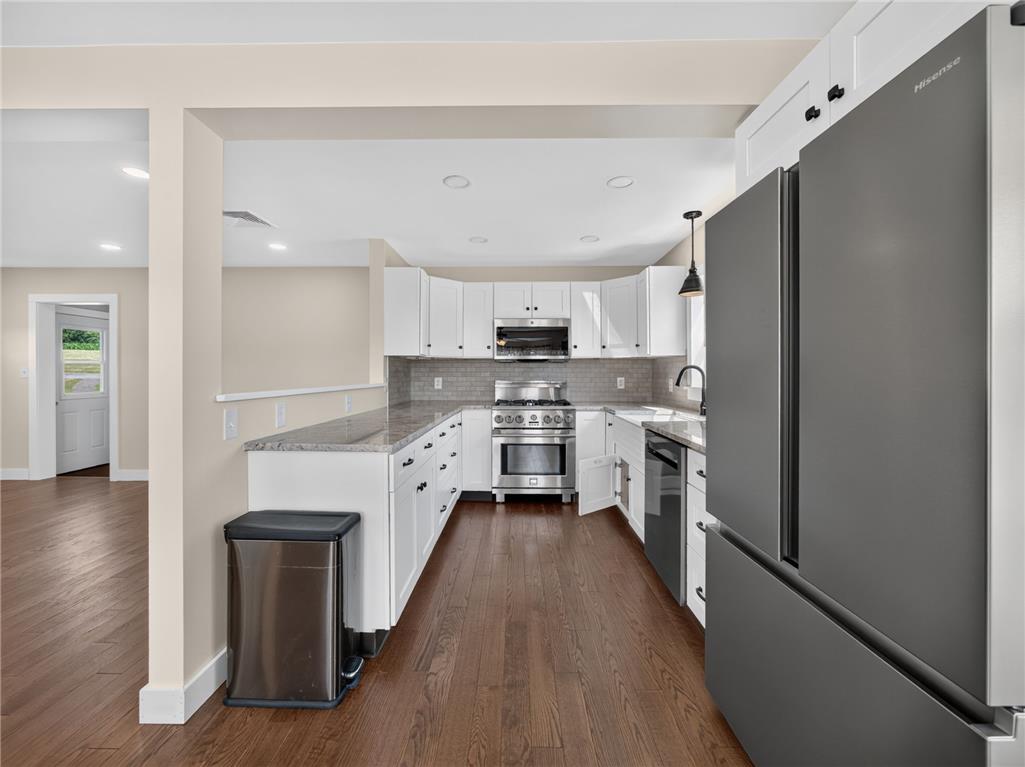 291 East Dannersville Road Bath, PA 18014 - Photo 30 of 46 A well-appointed kitchen features rich hardwood flooring and sleek stainless steel appliances, seamlessly connecting to an inviting living area.