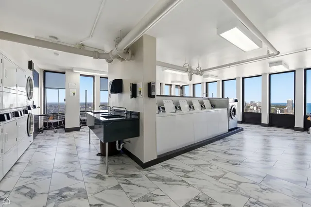 a view of a big room with lounge chair and windows