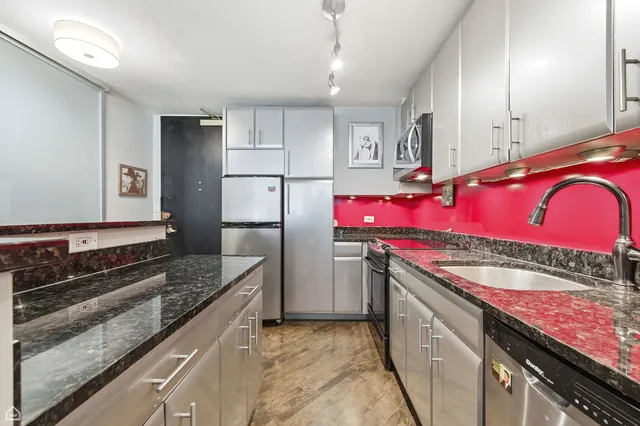 a kitchen with stainless steel appliances granite countertop a refrigerator and a stove