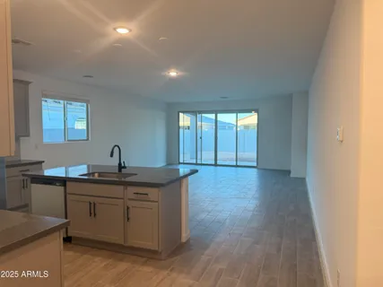 a kitchen with stainless steel appliances granite countertop a sink and wooden floors