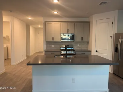a kitchen with kitchen island a refrigerator and a stove