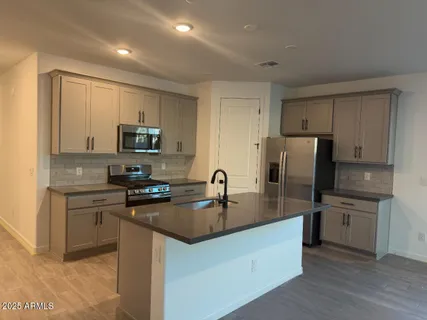 a kitchen with kitchen island granite countertop a sink stove and refrigerator