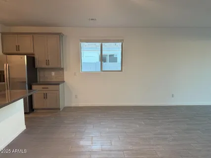 a view of a kitchen with a sink stove cabinets and empty room