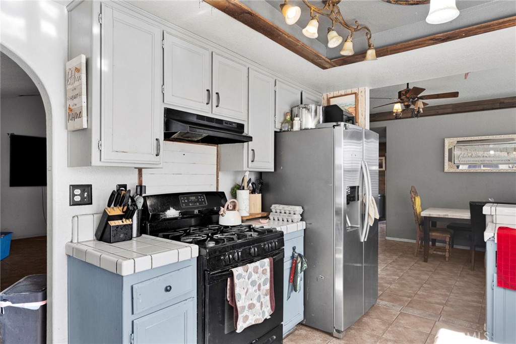 6414 Nielson Road Phelan, CA 92371 - Photo 25 of 74 a kitchen with stainless steel appliances granite countertop a refrigerator a stove a sink dishwasher and white cabinets with wooden floor