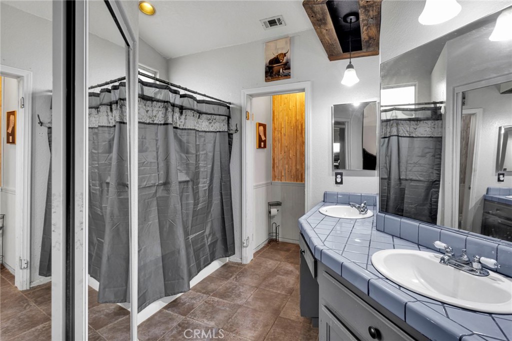 6414 Nielson Road Phelan, CA 92371 - Photo 47 of 74 a bathroom with a granite countertop sink a mirror and shower
