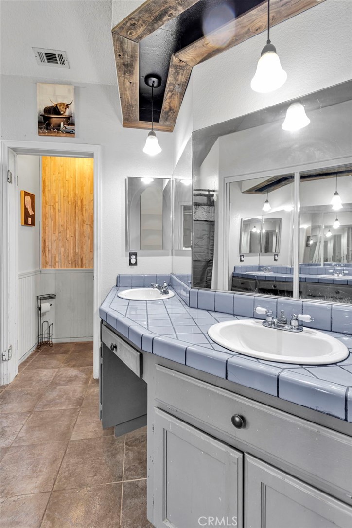 6414 Nielson Road Phelan, CA 92371 - Photo 48 of 74 a spacious bathroom with a granite countertop sink a toilet and a mirror