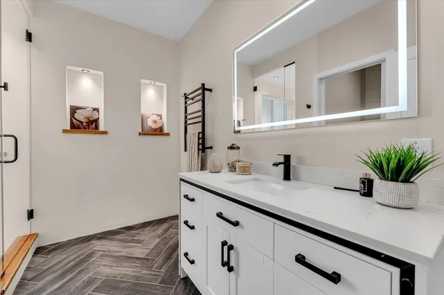 a bathroom with a granite countertop sink a mirror and vanity
