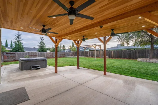 a view of a backyard with couches under an umbrella