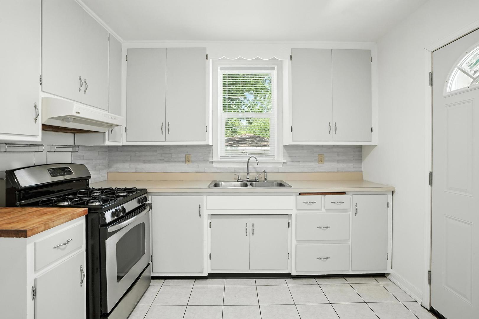 21149 Main Street Matteson, IL 60443 - Photo 13 of 20 a kitchen with cabinets appliances a sink and a window