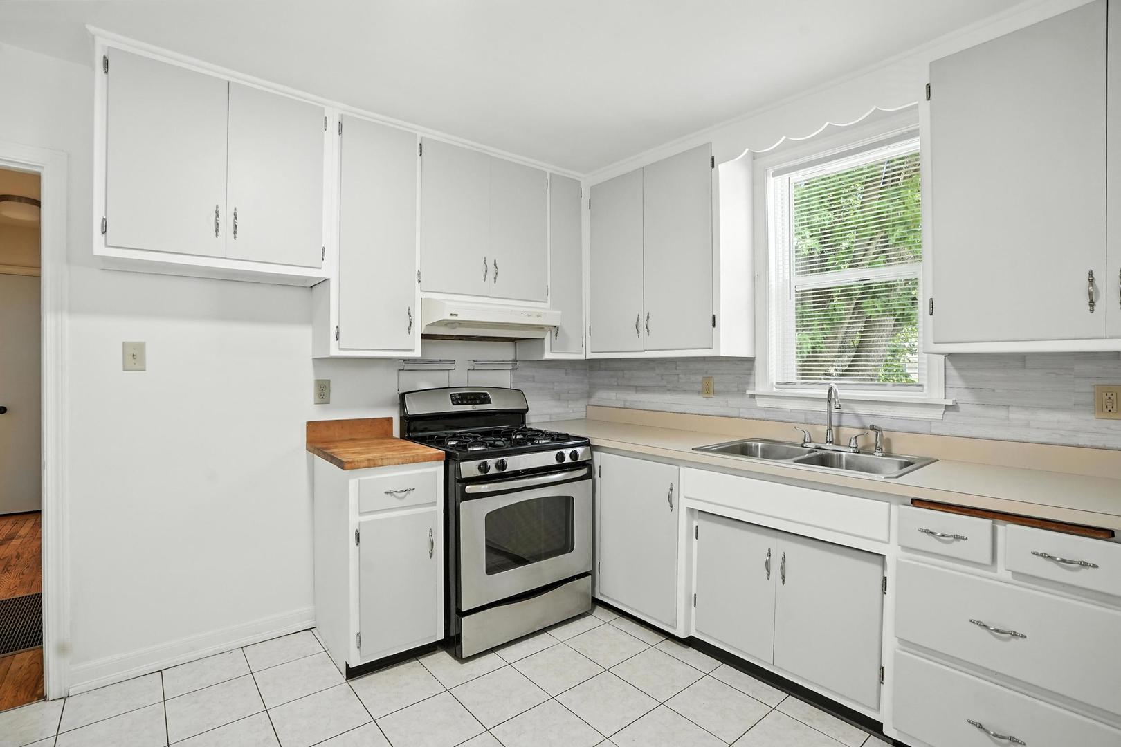 21149 Main Street Matteson, IL 60443 - Photo 14 of 20 a kitchen with white cabinets appliances and a window