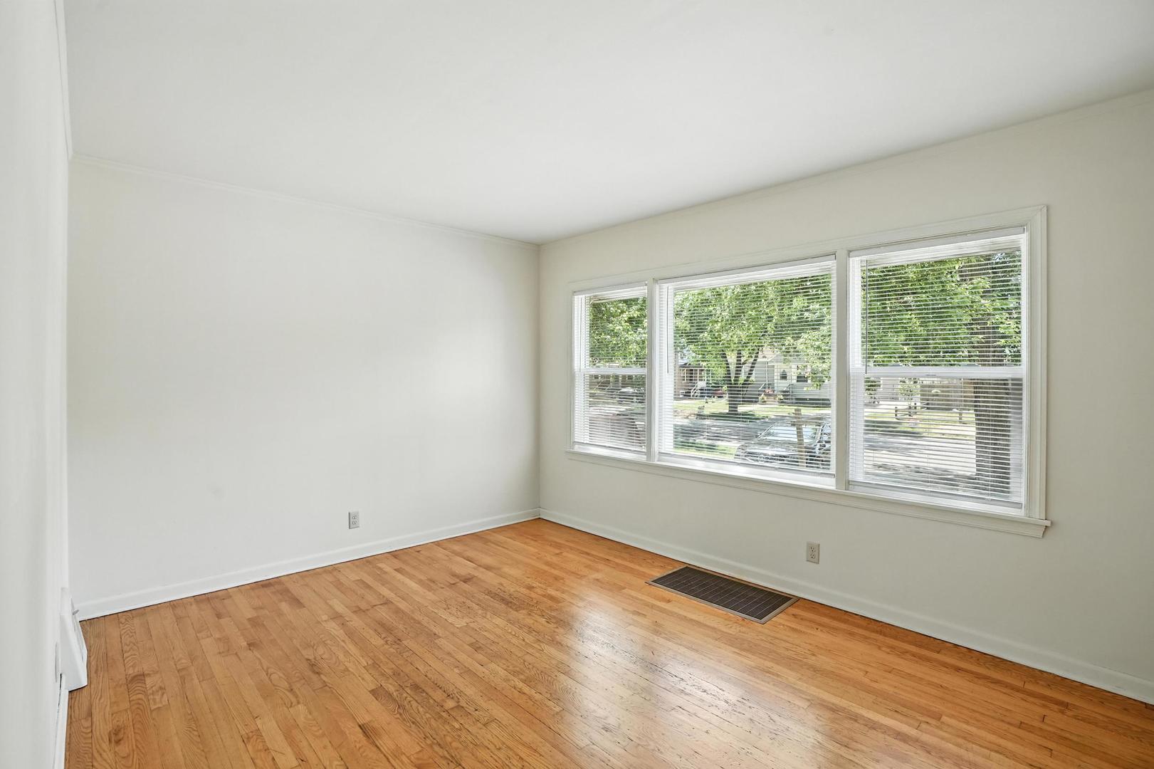 21149 Main Street Matteson, IL 60443 - Photo 5 of 20 an empty room with wooden floor and windows