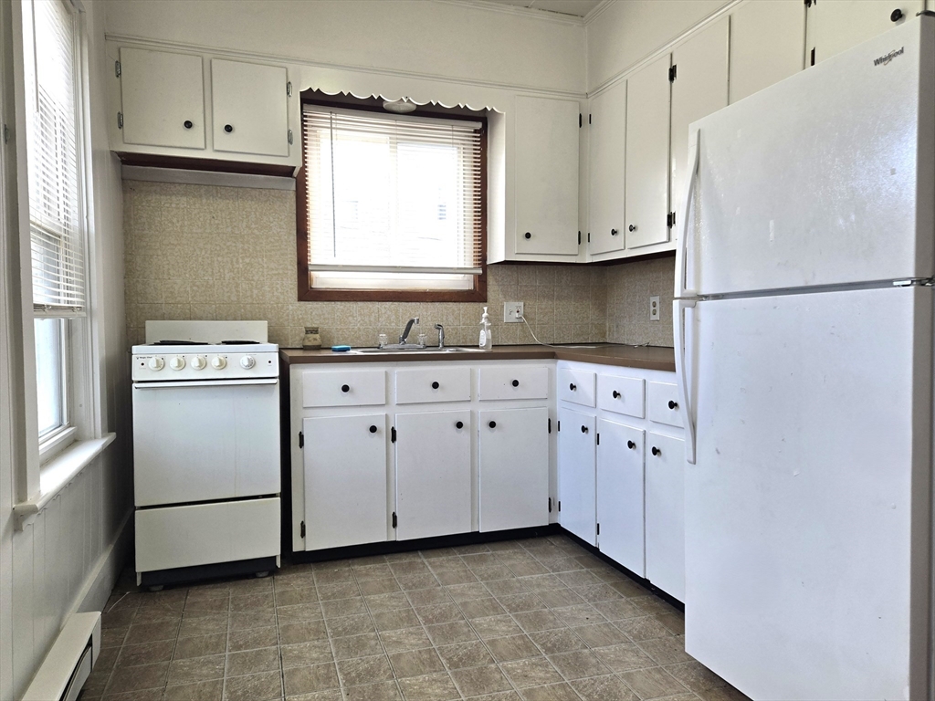 25 Myrtle Street, Unit 1F Taunton, MA 02780 - Photo 2 of 7 a kitchen with white cabinets and white appliances