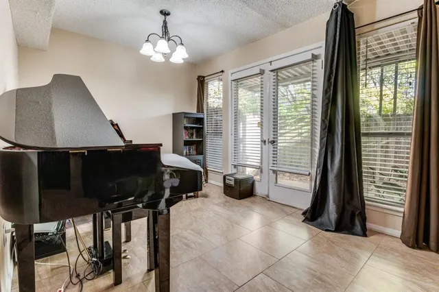 a living room with furniture a flat screen tv and a floor to ceiling window