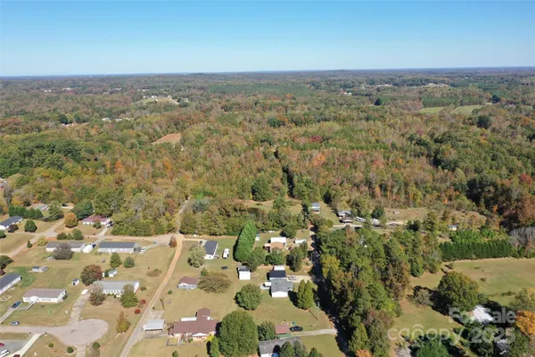 an aerial view of house with yard and mountain in the back