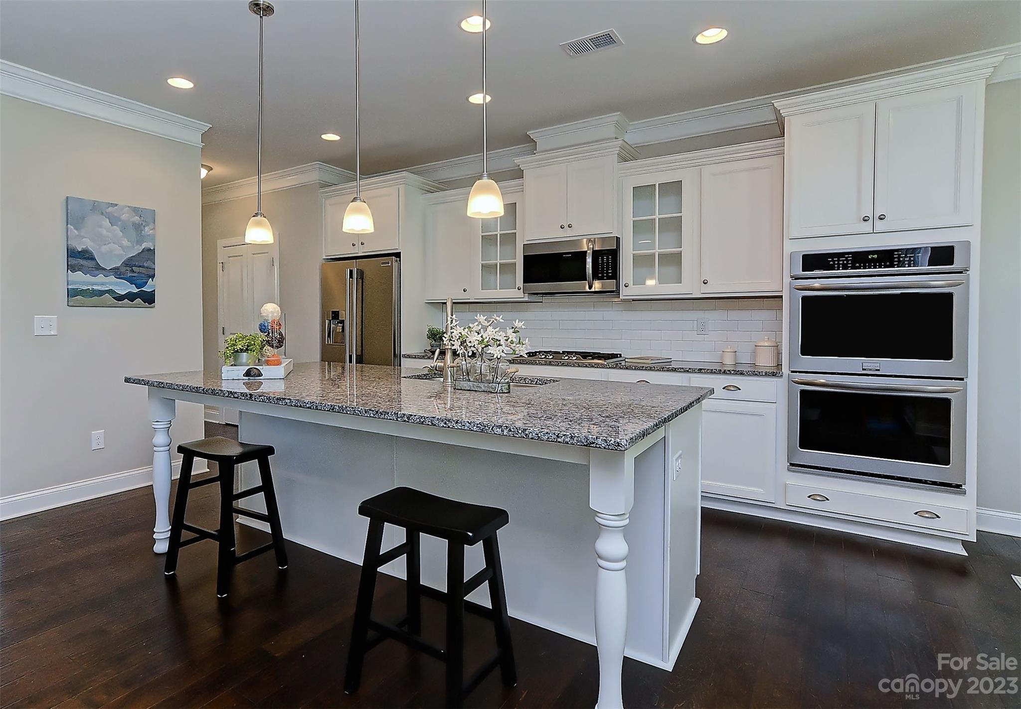11266 Trailside Road Concord, NC 28027 - Photo 17 of 45 a kitchen with stainless steel appliances kitchen island granite countertop a stove a sink and a microwave