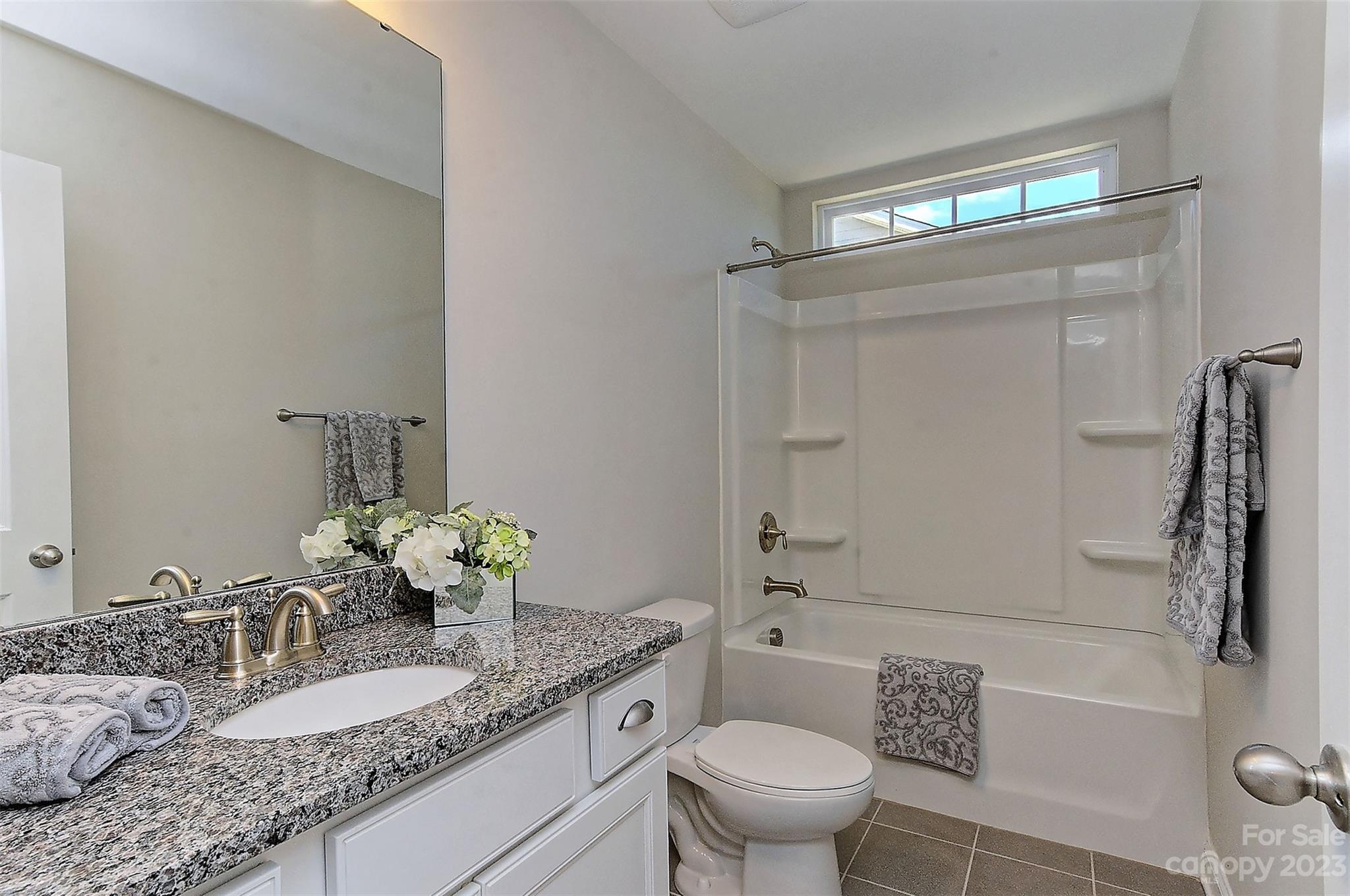 11266 Trailside Road Concord, NC 28027 - Photo 29 of 45 a bathroom with a granite countertop sink a toilet a mirror and shower