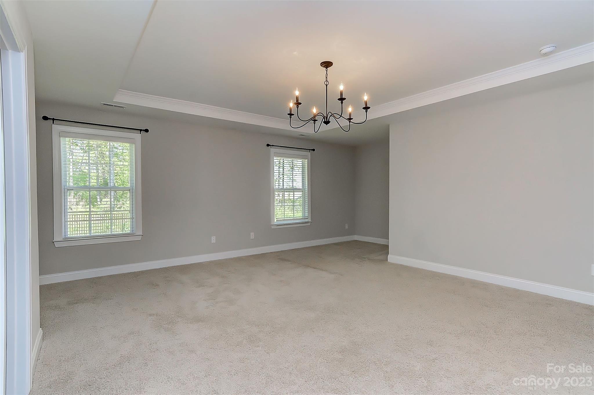 11266 Trailside Road Concord, NC 28027 - Photo 30 of 45 an empty room with chandelier and windows