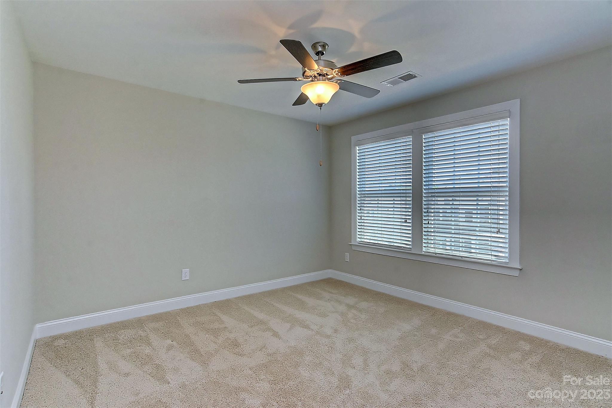 11266 Trailside Road Concord, NC 28027 - Photo 35 of 45 a view of an empty room with a ceiling fan and a window