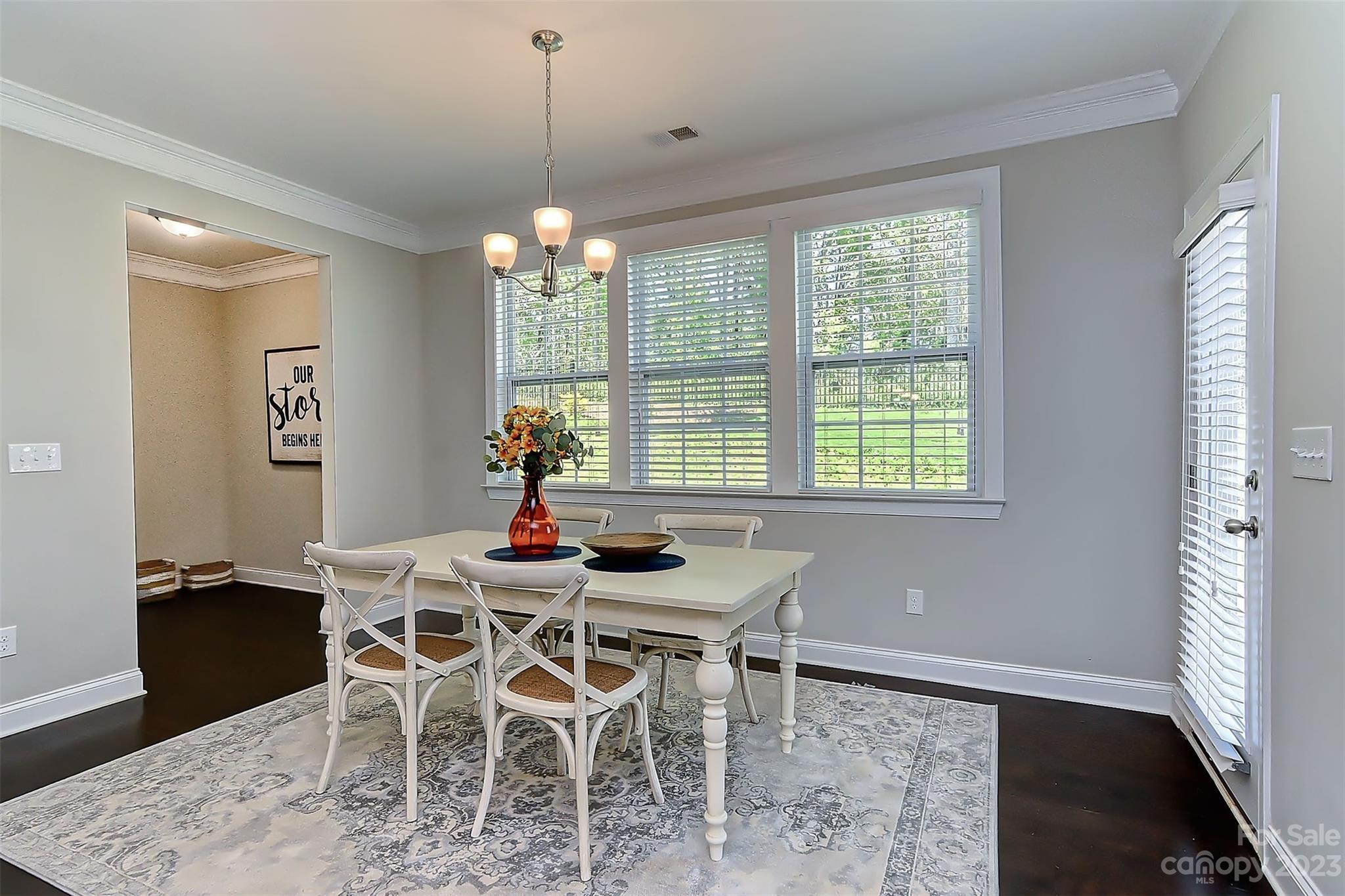 11266 Trailside Road Concord, NC 28027 - Photo 10 of 45 a dining room with furniture a chandelier and wooden floor