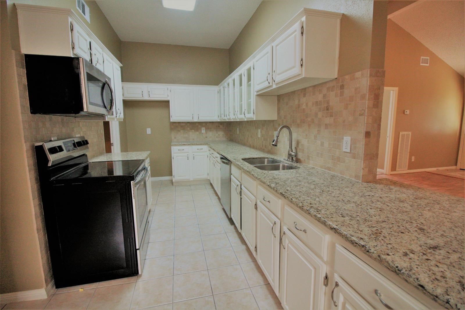 2618 Quarry Hill Road Sugar Land, TX 77478 - Photo 8 of 15 a kitchen with stainless steel appliances granite countertop a refrigerator a stove and a sink