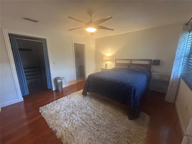a bedroom with a bed and wooden floor