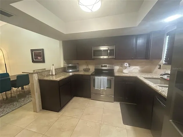 a kitchen with a sink and a stove top oven with wooden floor