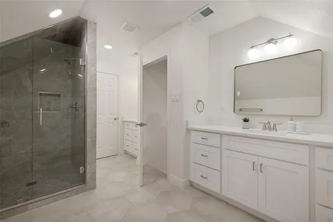 a bathroom with a double vanity sink mirror and shower